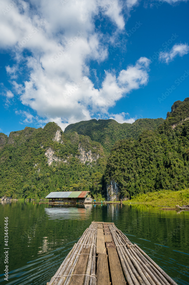 Obraz premium Landscape of lake with cleared blue sky, clouds, mountain and a floating house 