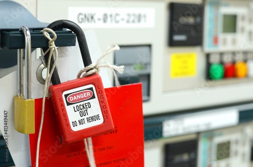 Red key lock and white tag for process cut off electrical on control panel in substation at chemical plants, power plants, oil & gas industry or onshore industry. isolation tag and do not remove tag.