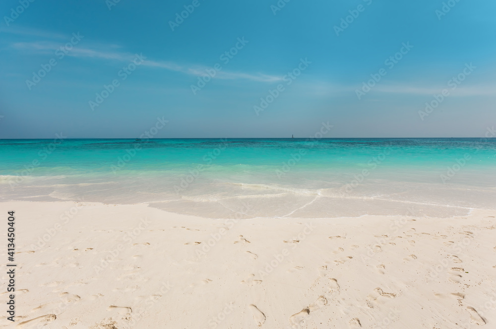 Wide beach with white sand on background of clear sky and blue ocean with waves. Tropical paradise. Seascape. Thailand. Island Bamboo