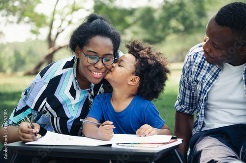 Happy education homework child black people family in garden with son kiss mom