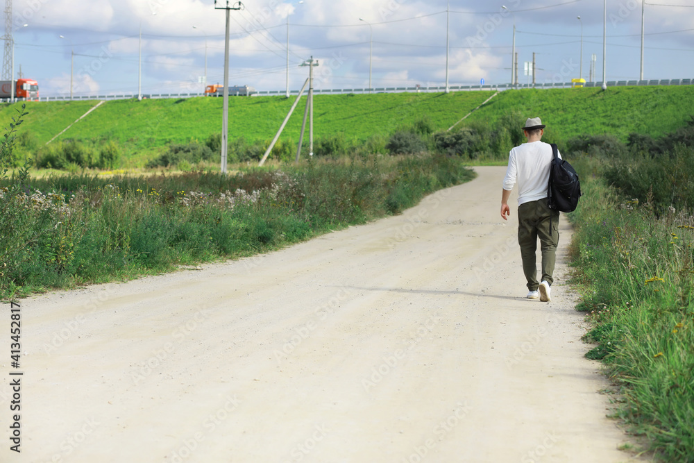 A man walks along a country road. Hitchhiker around the country. A man stops a passing car on the road. A man walks along a country road. Hitchhiker around the country. A man stops a passing car on the road.