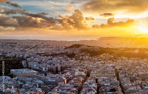 Panoramic view to the skyline of Athens, Greece, with Acropolis, Parthenon Temple, the Syntagma parliament and Piraeus harbour in the background during golden sunset time