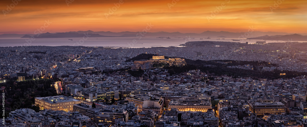 Panoramic view to the cityscape of Athens, Greece, with the illuminated Parthenon Temple of the Acropolis in the center and Syntagma Parliament during dusk