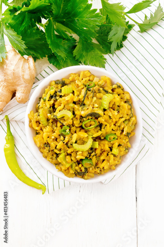 Kitchari with celery in bowl on board top photo