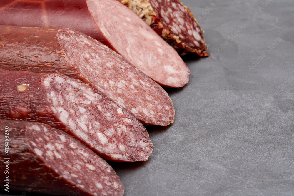 A set of smoked sausages with a cut on them. Gray background with copy space. Close-up. A set of smoked sausages with a cut on them. Gray background with copy space. Close-up.
