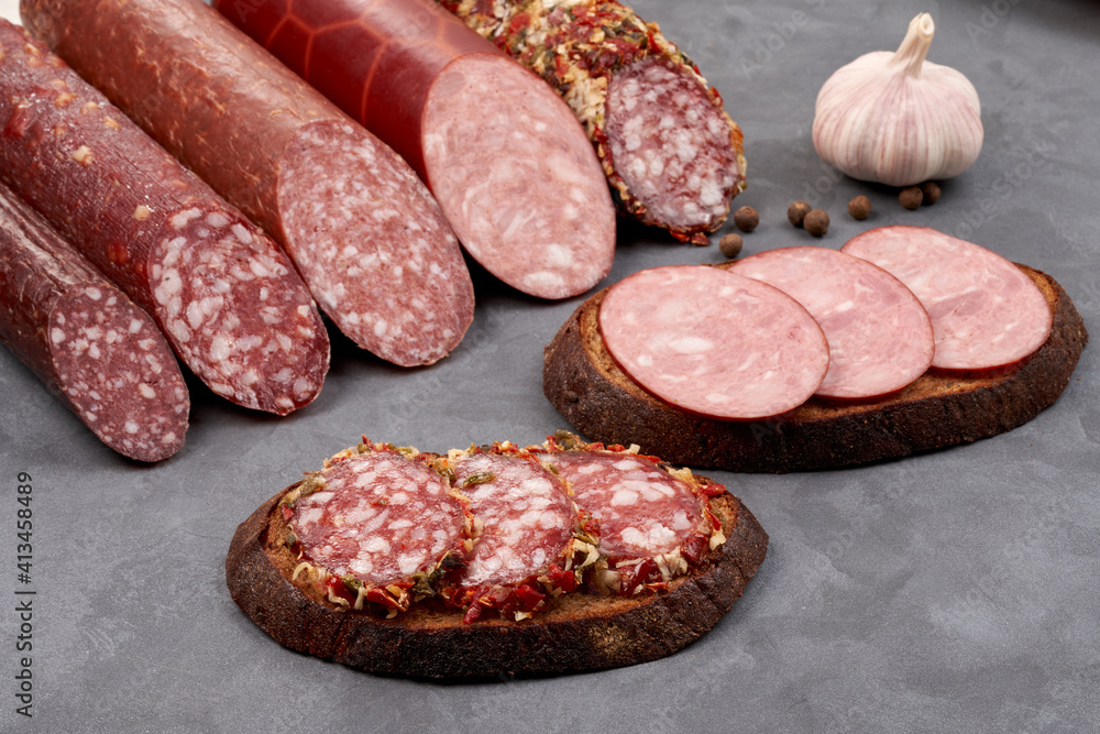 A set of smoked sausages and sandwiches with black bread made from it. Close-up still life. A set of smoked sausages and sandwiches with black bread made from it. Close-up still life.