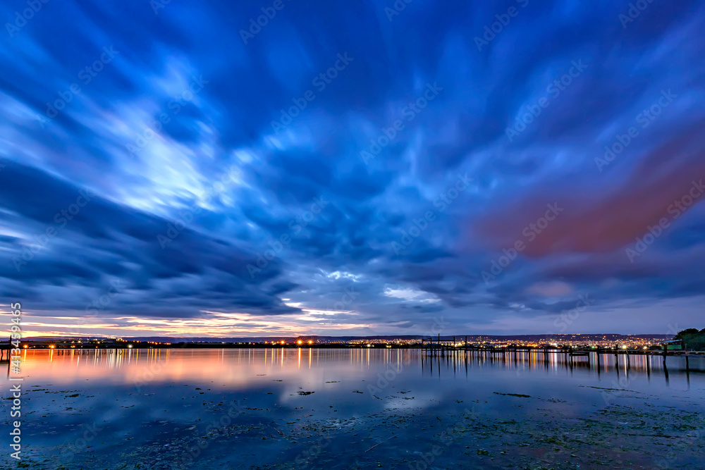 blue hour. Stunning long exposure landscape with city lights at horizon