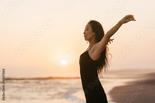 Smile Freedom and happiness chinese woman on beach. She is enjoying serene ocean nature during travel holidays vacation outdoors. asian beauty. summer time