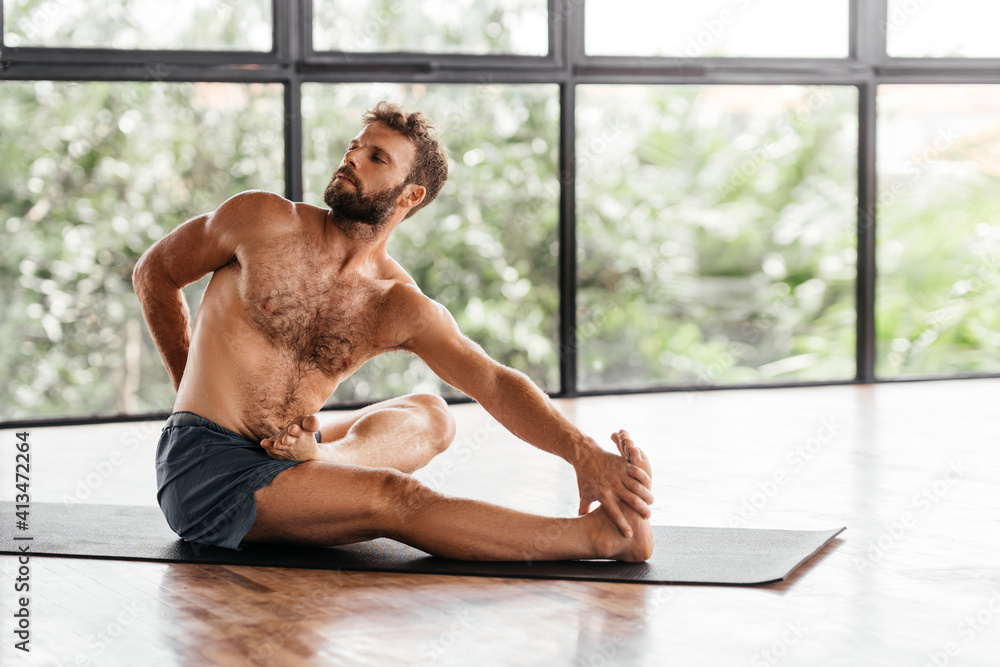 Yoga men workout in studio, training in front of a window