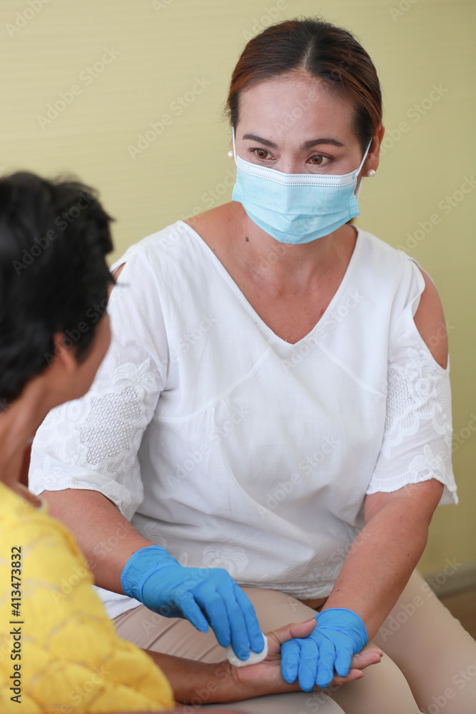 Asian woman wearing protective hygiene mask  taking care of her elder mother with love