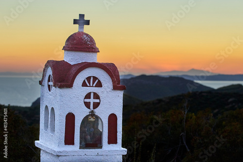 A roadside chapel with a picturesque sunset over the sea in the background - Sythonia, Halkidiki Peninsula, Greece photo