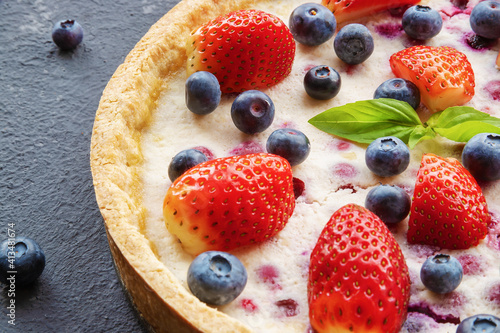 cheesecake with strawberries and blueberries on concrete backgro
