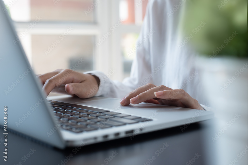 Close up of female hands typing on laptop computer surfing the internet, woman online working from home