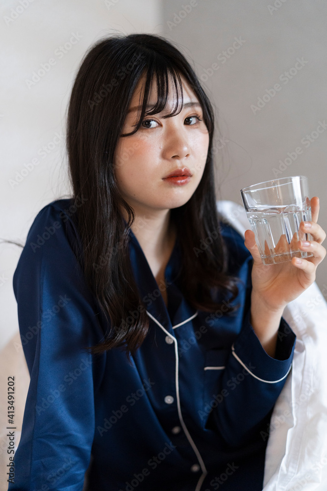 ベッドで水を飲むパジャマの
女性 ベッドで水を飲むパジャマの
女性