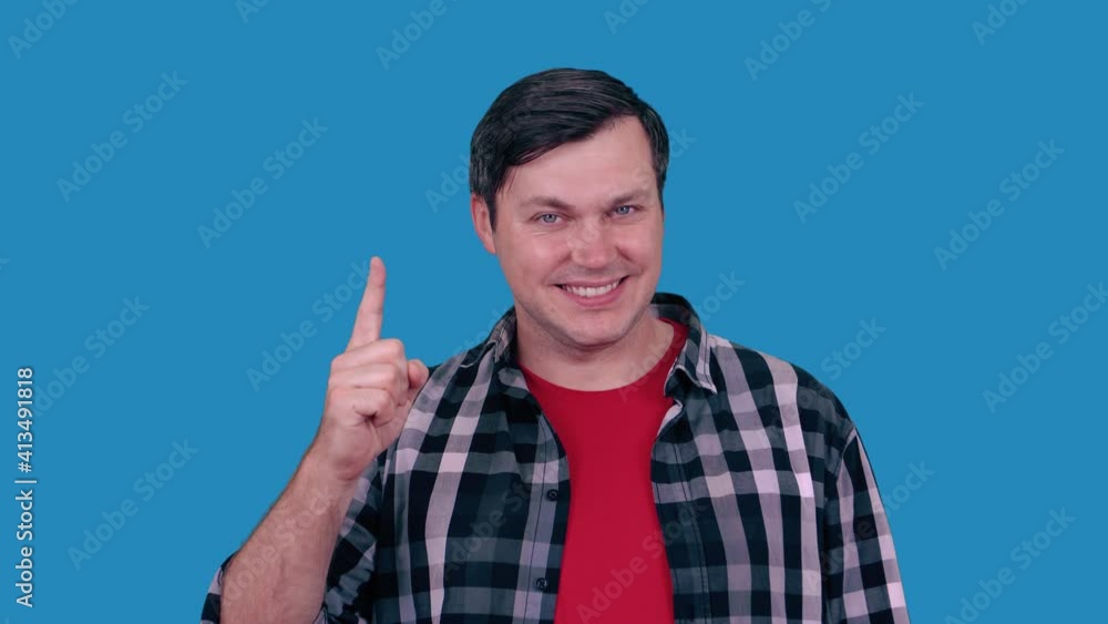 Attractive, joyful, positive, cheerful guy has finally found a solution to how to do exercises by raising his hand, isolated on a sled background. Attractive, joyful, positive, cheerful guy has finally found a solution to how to do exercises by raising his hand, isolated on a sled background.