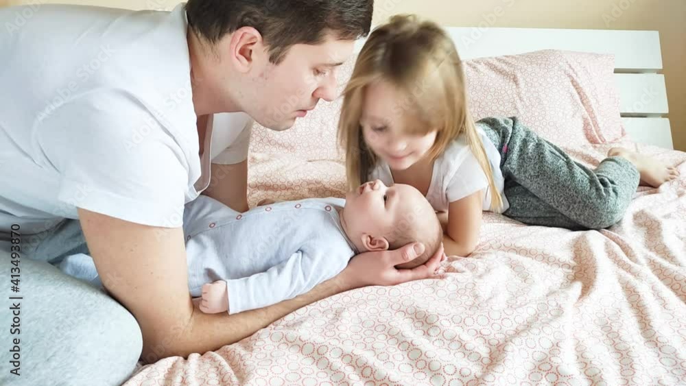 Happy family. Father and his two little daughters are spending morning time on fun in parents bed. Happy family. Father and his two little daughters are spending morning time on fun in parents bed.
