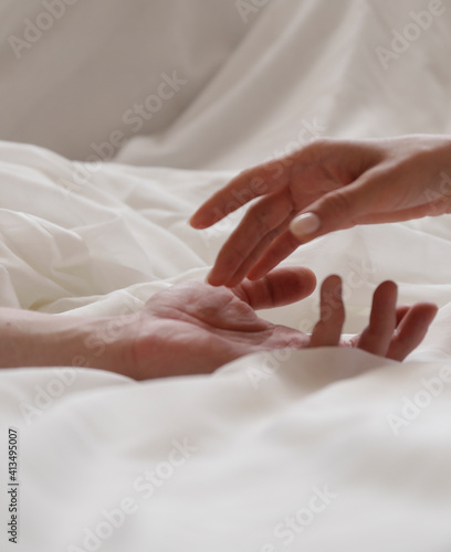 Make love. Young male and female hands on bed, closeup, empty space
