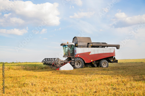 old combine harvester harvests from the field