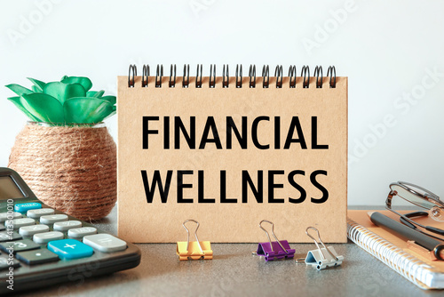 Notebook with text Financial Wellness near office supplies.