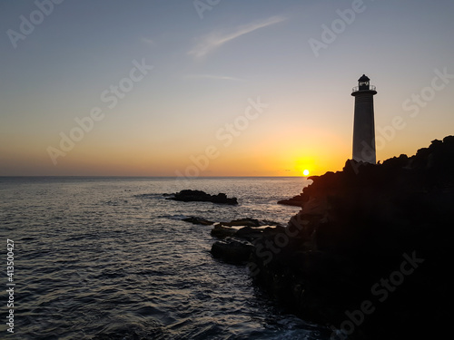 lighthouse at sunset in the sea