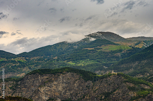 Paesaggio con cime di montagna nascoste parzialmente da nuvole grigie photo