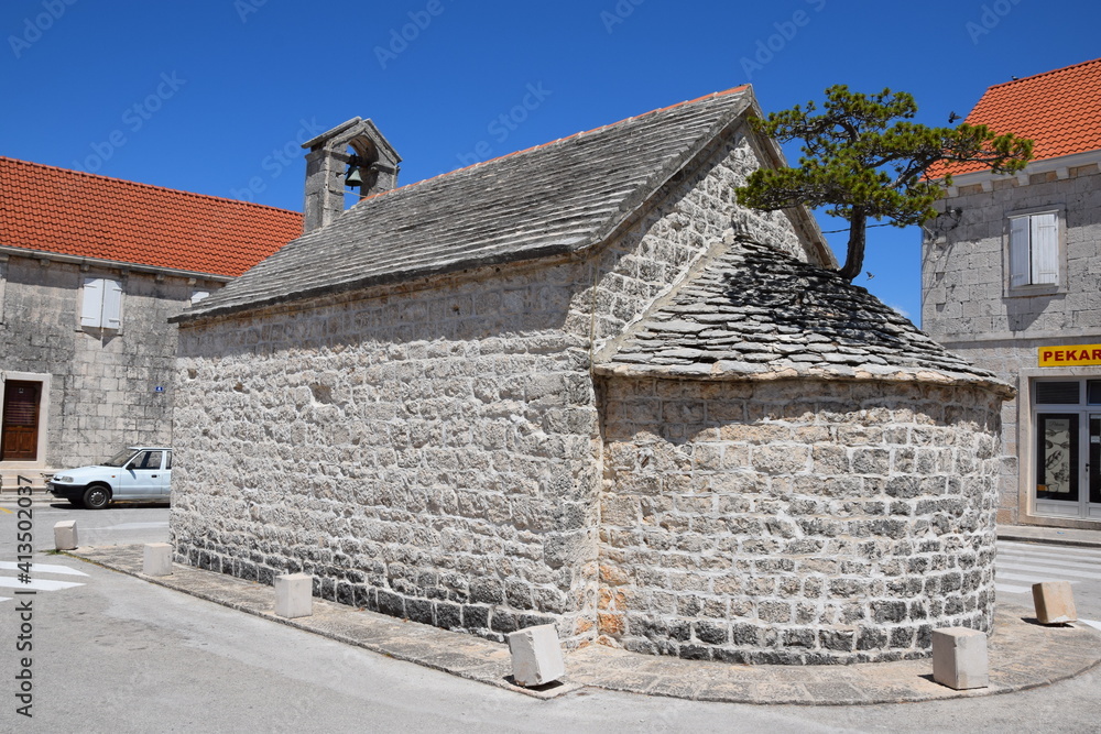 A church with a tree growing from roof on the island of Brac, Croatia  
