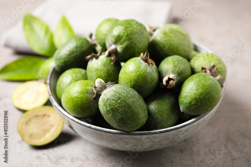Fresh green feijoa fruits on light grey table, closeup