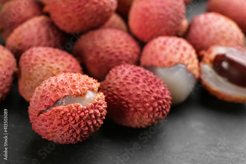 Fresh ripe lychee fruits on black table, closeup