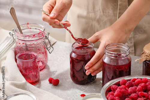 Valokuva Woman with jars of sweet raspberry jam