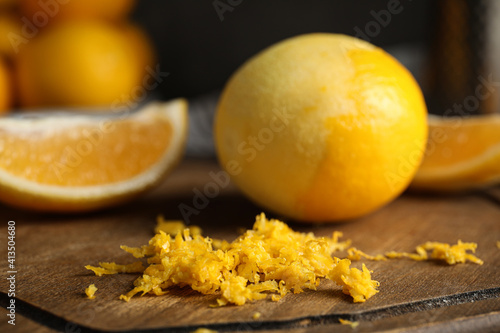 Lemon zest and fresh fruits on wooden board, closeup