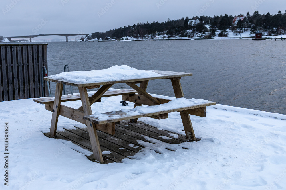 Wooden bench and table covered with snow on a cold winter day.Shot in Sweden, Scandinavia