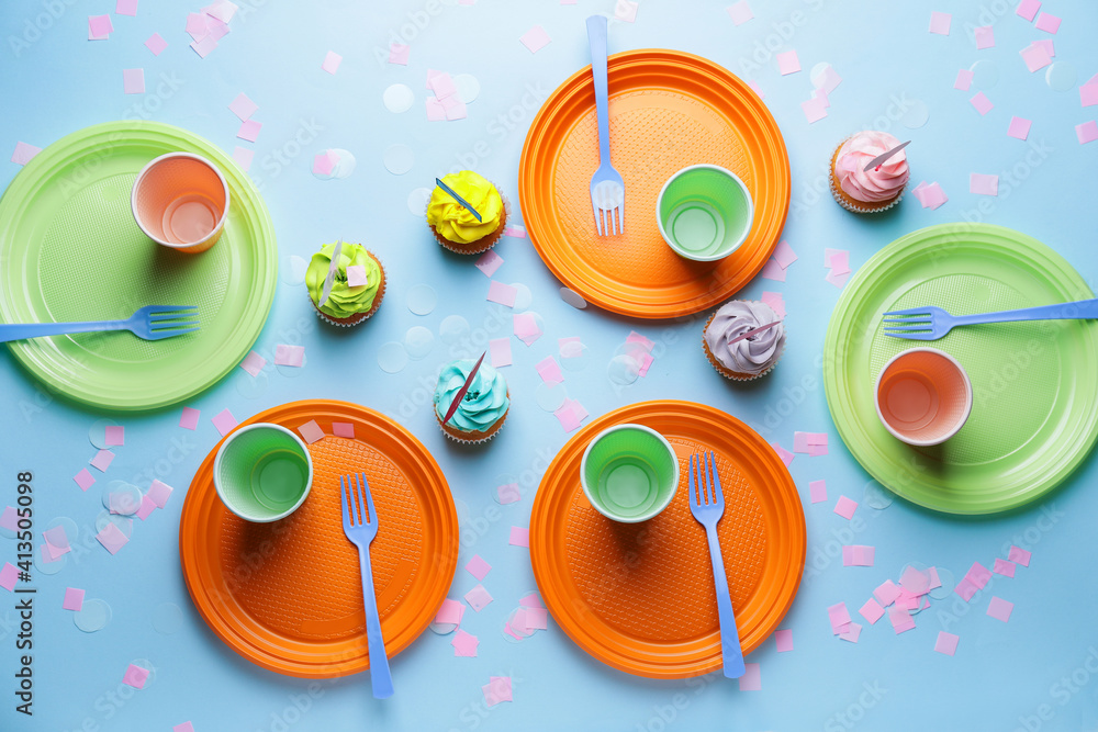 Plastic tableware and cupcakes on color background Plastic tableware and cupcakes on color background