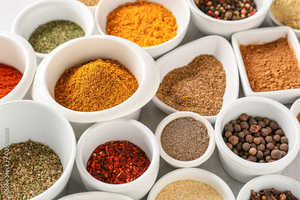 Bowls with different spices on light background, closeup Bowls with different spices on light background, closeup