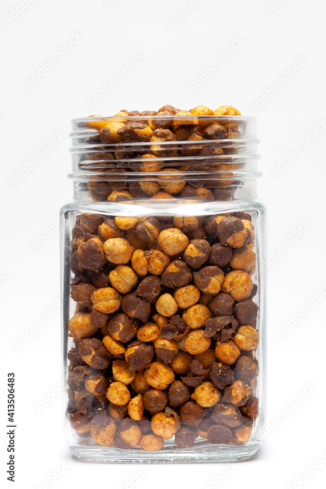 Crunchy Roasted Chana Masala in glass jar , made with Bengal Grams or Chickpeas. Pile of Indian spicy snacks (Namkeen), under top lighting, Front view, against the white background. Crunchy Roasted Chana Masala in glass jar , made with Bengal Grams or Chickpeas. Pile of Indian spicy snacks (Namkeen), under top lighting, Front view, against the white background.