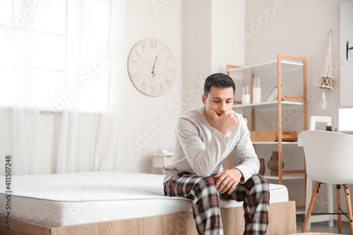 Young man in pajamas sittin...