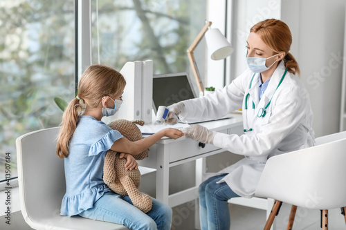 Pediatrician examining litt...