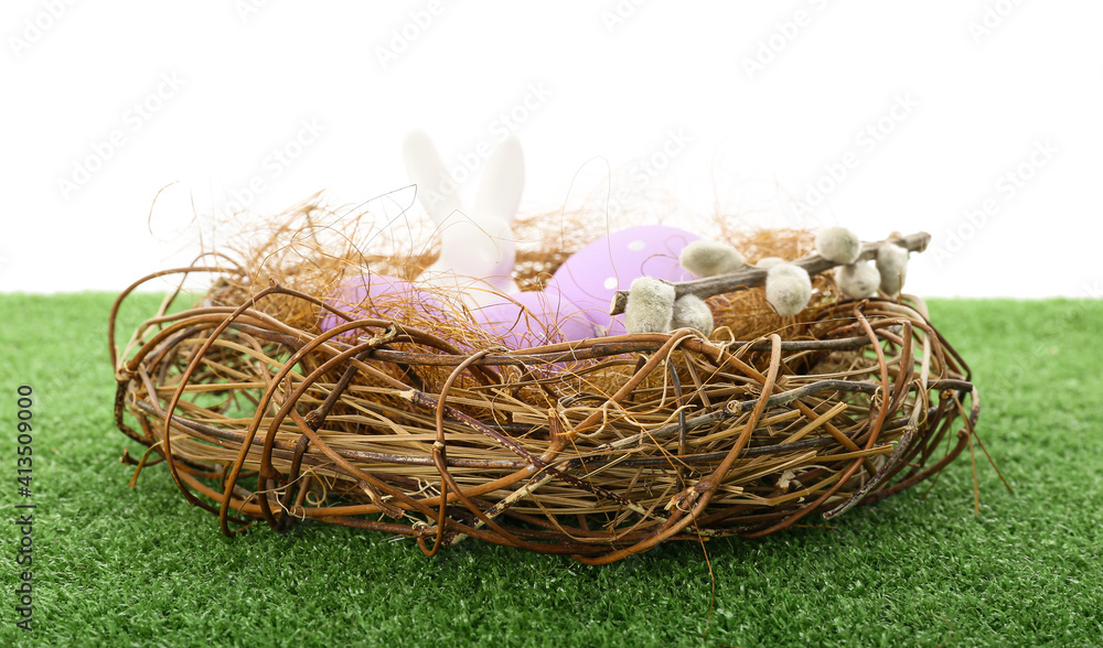 Nest with Easter eggs on grass against white background Nest with Easter eggs on grass against white background