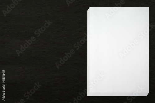 黒い机の上に置いた白いコピー用紙の束 © RewSite