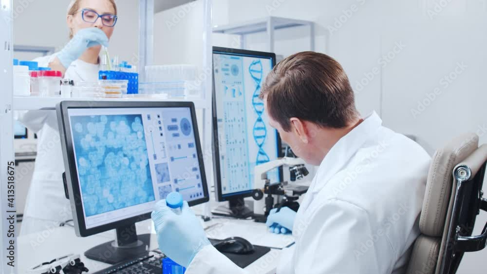 Professional team of scientists is working on a vaccine in a modern scientific research laboratory. Genetic engineer workplace. Future technology and science. Professional team of scientists is working on a vaccine in a modern scientific research laboratory. Genetic engineer workplace. Future technology and science.