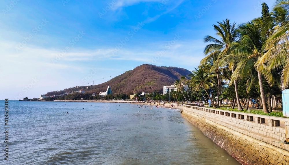 View of Front Beach. Coastline of Vung Tau. Sea, palm trees and hill. Vietnam. South-East Asia	