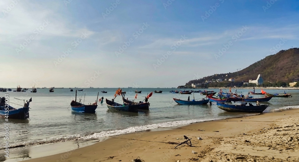 Fishing boats near Front Beach. Coastline of Vung Tau. Sea, palm trees and hill. Vietnam. South-East Asia	