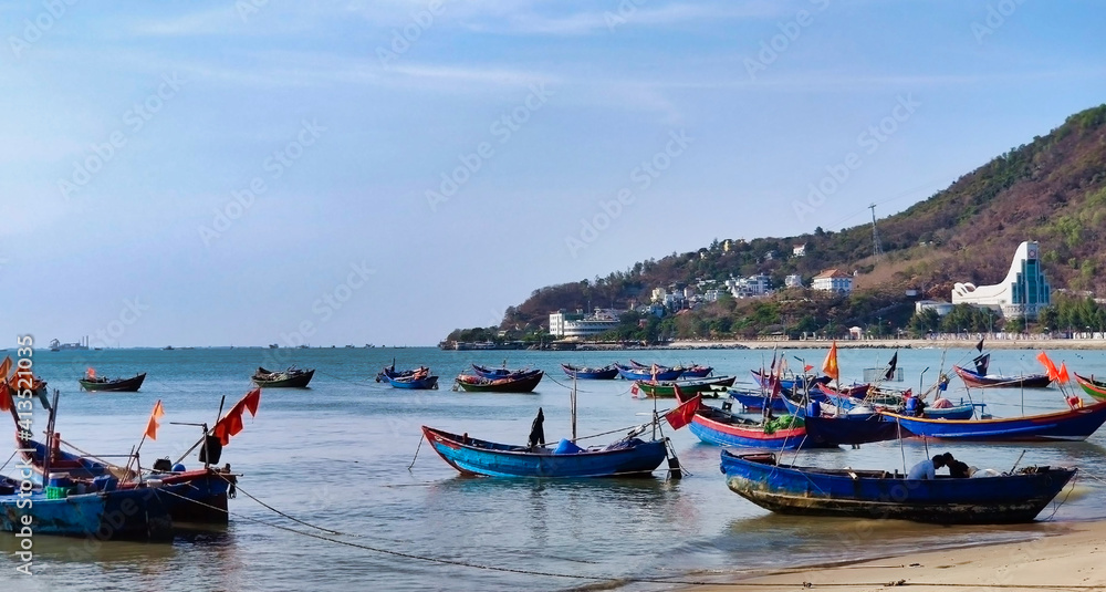 Fishing boats near Front Beach. Coastline of Vung Tau. Sea, palm trees and hill. Vietnam. South-East Asia	