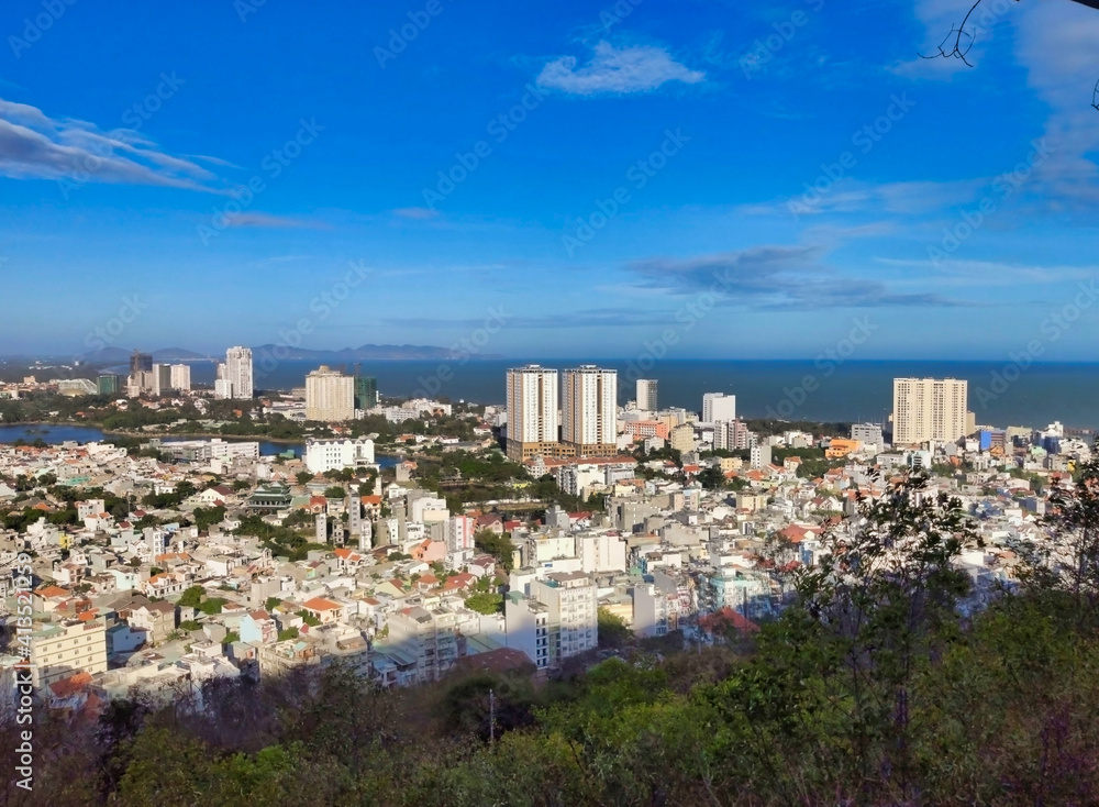 View of the houses and sea in the city of Vung Tau from above. Hills and sky. Vietnam. South-East Asia