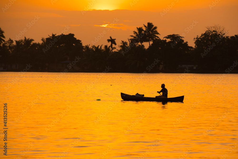 silhouette of a person in a boat in sunrise 