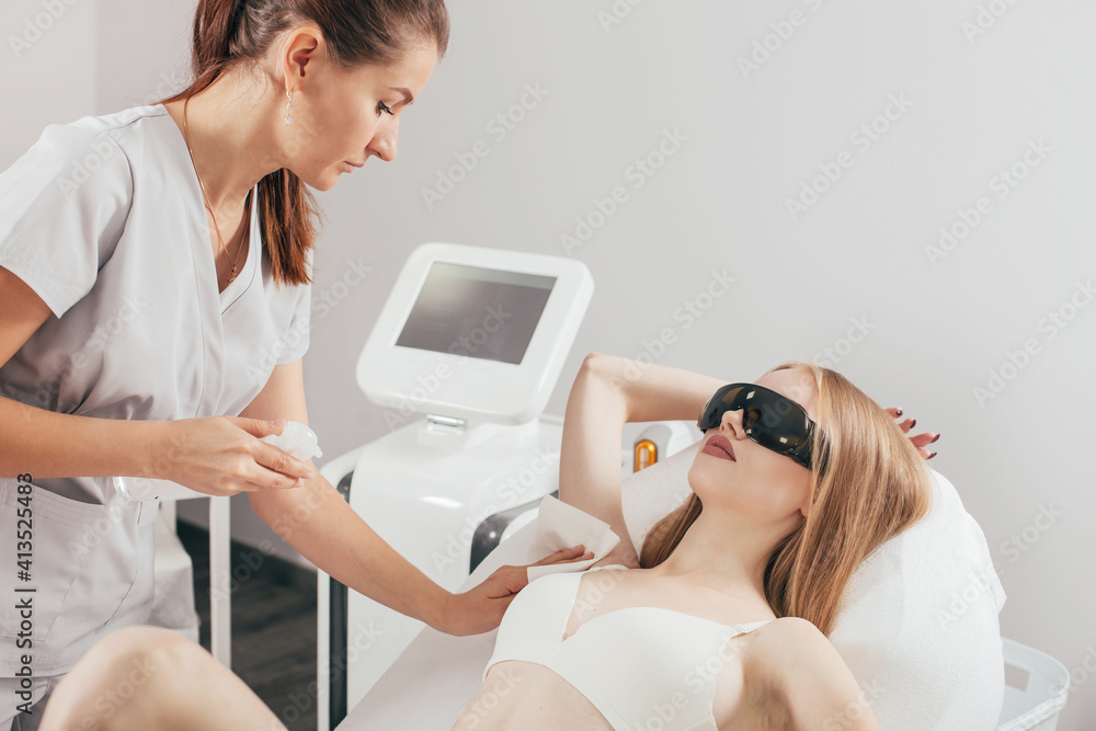 Smooth skin under the arms. Woman on laser hair removal. Blonde woman having underarm Laser hair removal epilation. Laser treatment in cosmetic salon. Body Care. Hairless Smooth And Soft Skin. Smooth skin under the arms. Woman on laser hair removal. Blonde woman having underarm Laser hair removal epilation. Laser treatment in cosmetic salon. Body Care. Hairless Smooth And Soft Skin.