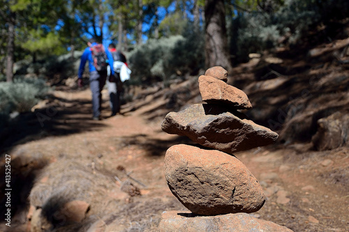 Gran Canaria, Spain -March 23, 2020: Hikers climbing a path where you can see a mark of stones
