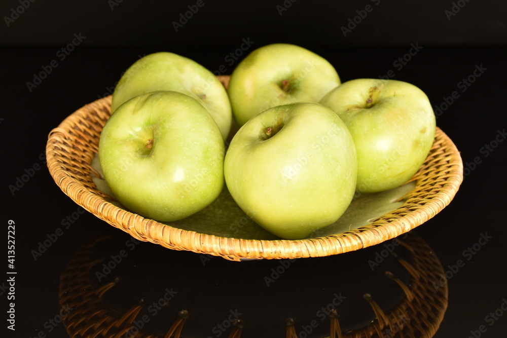 Several natural green apples by Renet Simirenko with a ceramic plate, close-up, isolated on black. Several natural green apples by Renet Simirenko with a ceramic plate, close-up, isolated on black.