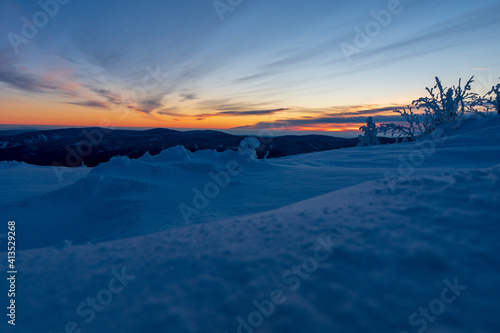 Fototapeta Naklejka Na Ścianę i Meble -  Sunrise or sunset in the winter mountains landscape. Yellow and blue clouds in the morning in czech republick