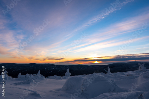 Sunrise or sunset in the winter mountains landscape. Yellow and blue clouds in the morning in czech republick