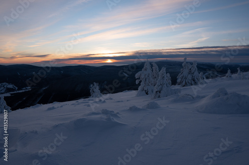 Sunrise or sunset in the winter mountains landscape. Yellow and blue clouds in the morning in czech republick photo